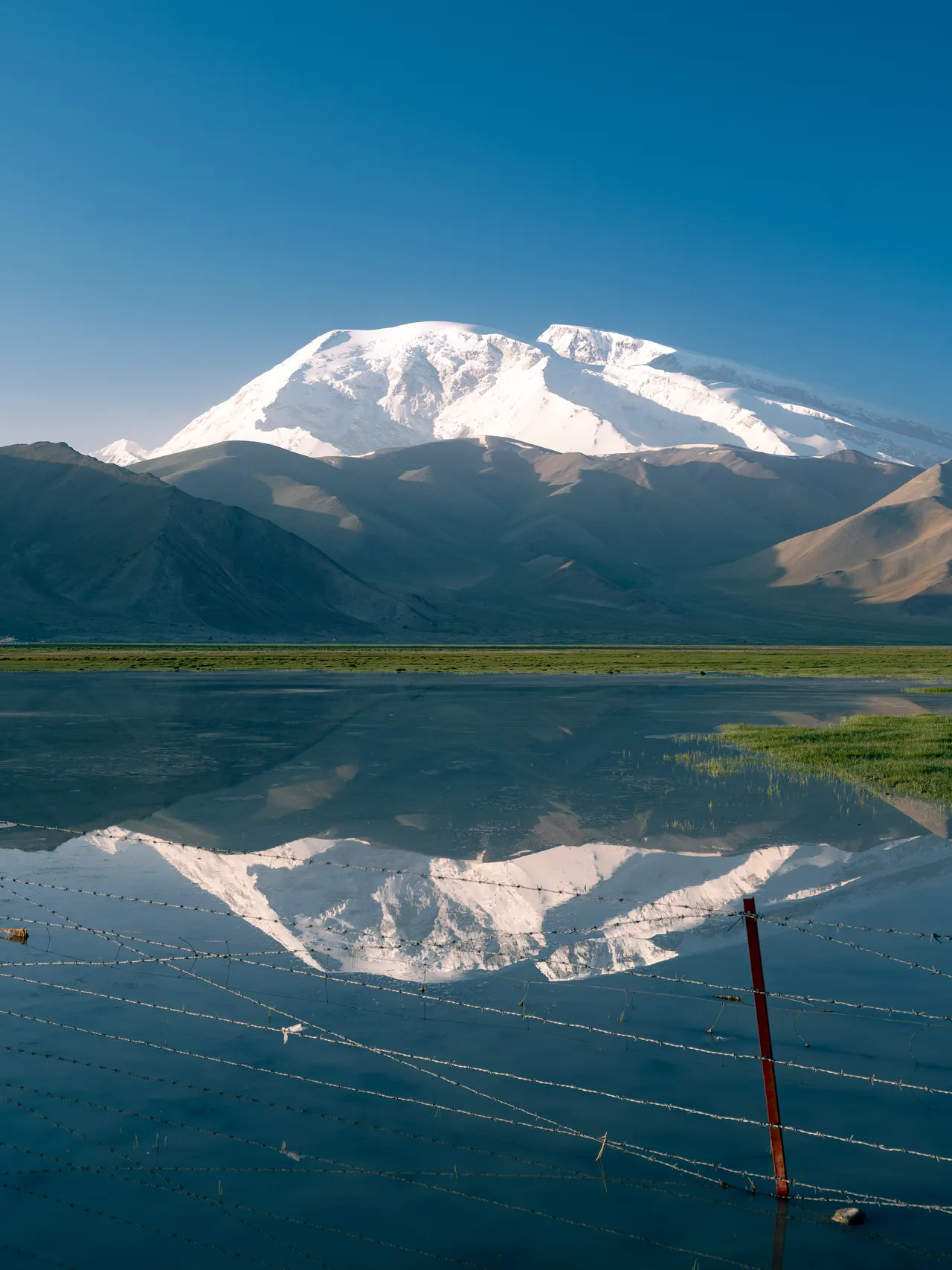 A snow-covered mountain reflected in a still lake